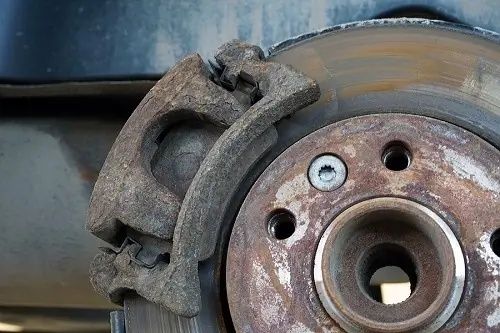 Close-up of a heavily rusted brake caliper and brake disc